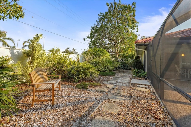 view of yard featuring glass enclosure and a patio area