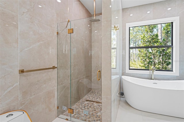 full bathroom with a stall shower, a healthy amount of sunlight, and a freestanding bath