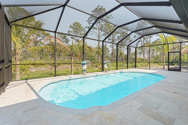 outdoor pool featuring glass enclosure and a patio area