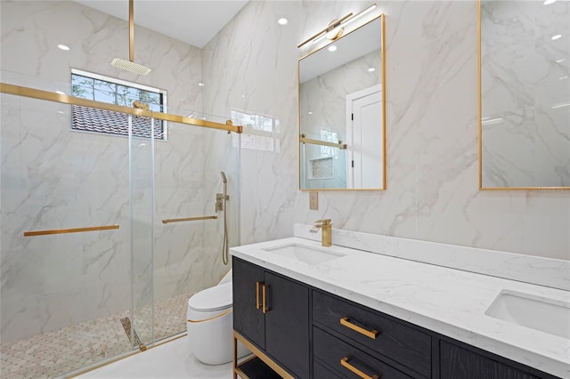 full bathroom with toilet, double vanity, a sink, and a marble finish shower