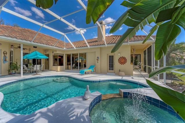 view of pool with ceiling fan, glass enclosure, a patio area, and a pool with connected hot tub