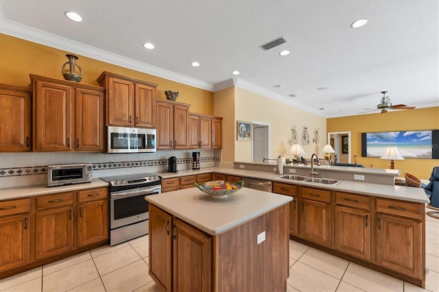 kitchen featuring stainless steel appliances, light countertops, visible vents, a sink, and a peninsula