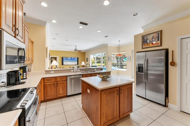 kitchen featuring stainless steel appliances, light countertops, crown molding, and a sink