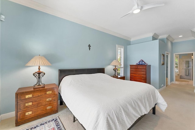 bedroom featuring light colored carpet, ensuite bathroom, ornamental molding, a ceiling fan, and baseboards