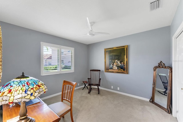 home office featuring light carpet, ceiling fan, visible vents, and baseboards