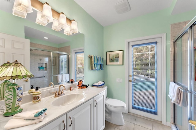 bathroom featuring a wealth of natural light, a stall shower, vanity, and tile patterned floors