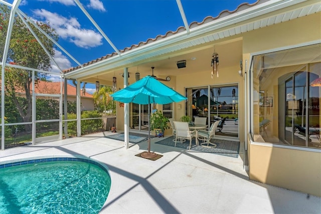 pool featuring glass enclosure and a patio