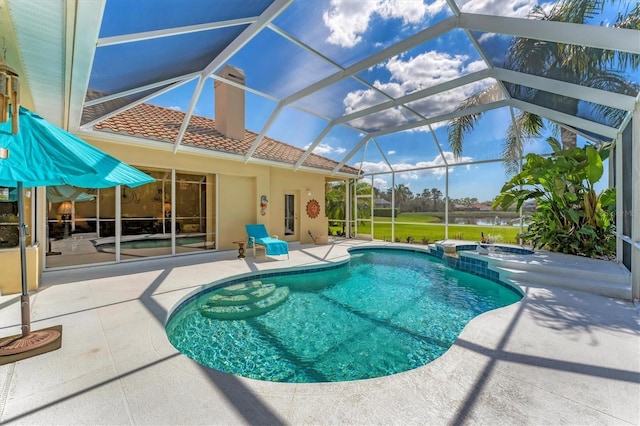 view of pool with a lanai, a pool with connected hot tub, and a patio