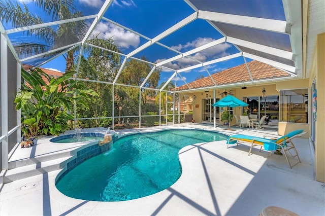 view of swimming pool featuring glass enclosure, a pool with connected hot tub, and a patio