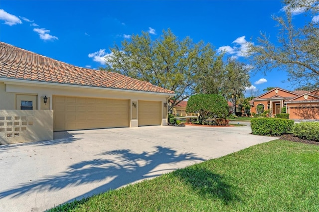 exterior space with a garage, a tile roof, and stucco siding