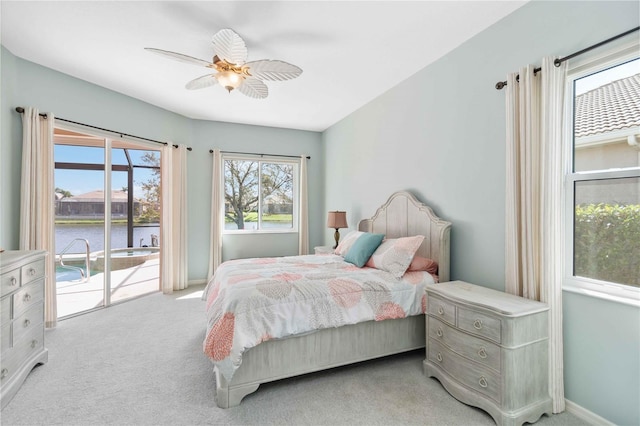 carpeted bedroom with a water view, access to outside, baseboards, and ceiling fan