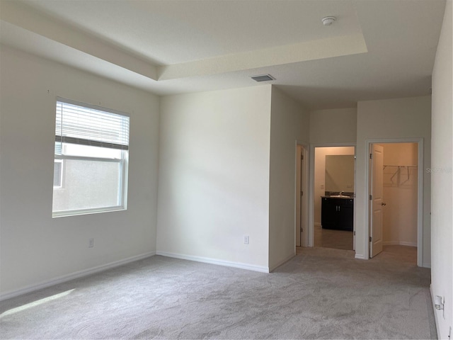 carpeted spare room featuring visible vents and baseboards