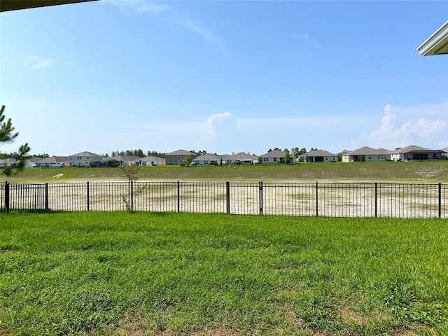 view of yard featuring fence and a residential view