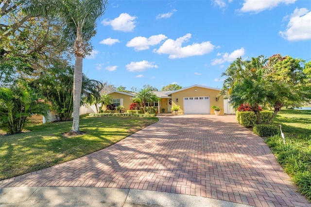 ranch-style home with a garage, a front lawn, decorative driveway, and stucco siding