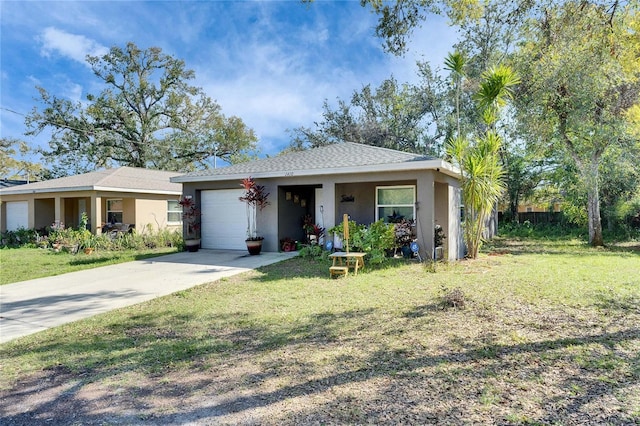 view of front of house featuring a front yard, driveway, an attached garage, and stucco siding