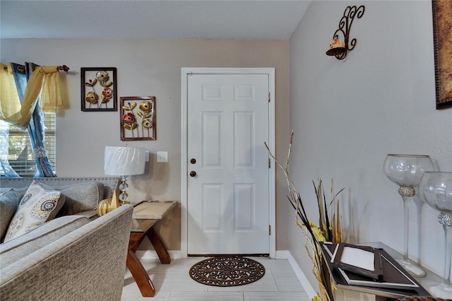 entryway with light tile patterned floors and baseboards