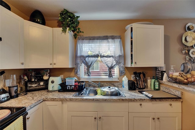 kitchen featuring a sink, white cabinetry, and black electric range oven