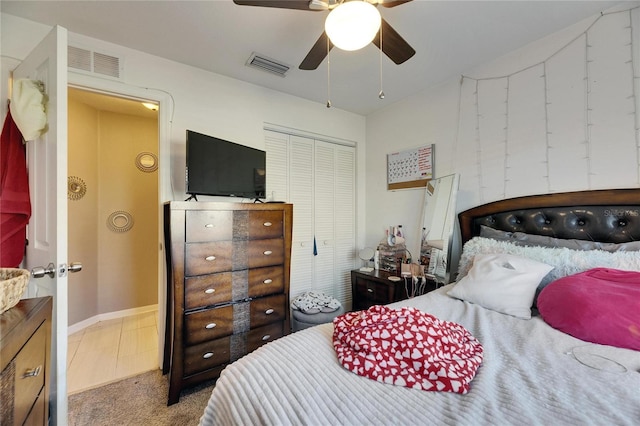 carpeted bedroom with a ceiling fan, a closet, and visible vents