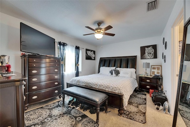 bedroom with carpet, visible vents, and a ceiling fan