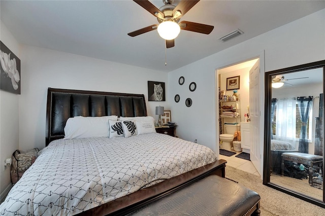 bedroom with light tile patterned floors, connected bathroom, visible vents, and a ceiling fan