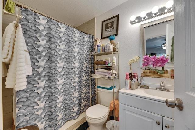 bathroom featuring a textured wall, toilet, a shower with shower curtain, a textured ceiling, and vanity