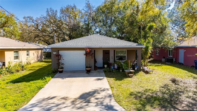 ranch-style home with a shingled roof, concrete driveway, a front yard, a garage, and cooling unit