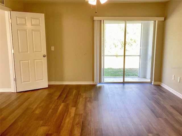 empty room with dark wood-style flooring and baseboards