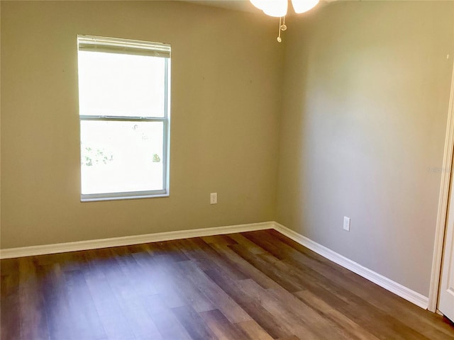 empty room featuring dark wood-type flooring and baseboards