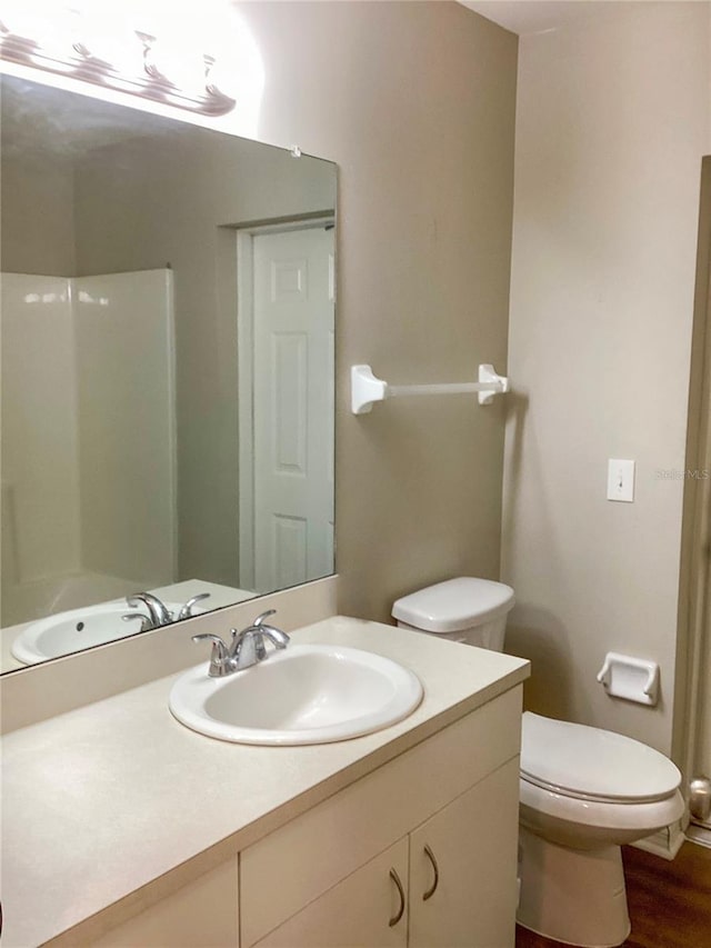 full bathroom featuring vanity, toilet, and wood finished floors