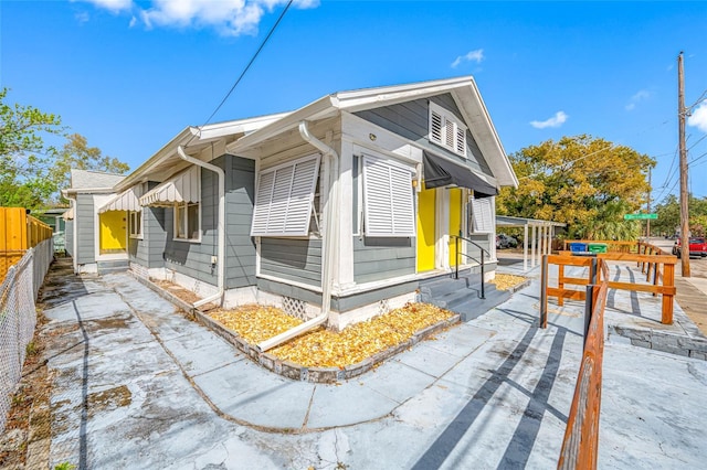 view of side of home with entry steps and fence