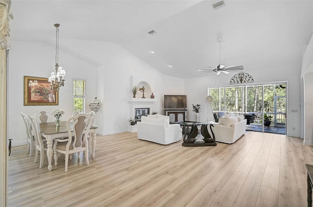 living room with a glass covered fireplace, light wood-style floors, visible vents, and a healthy amount of sunlight