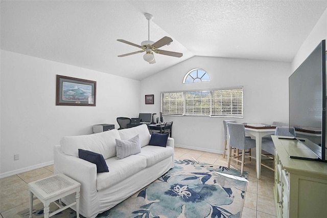 living area featuring a ceiling fan, baseboards, lofted ceiling, light tile patterned flooring, and a textured ceiling