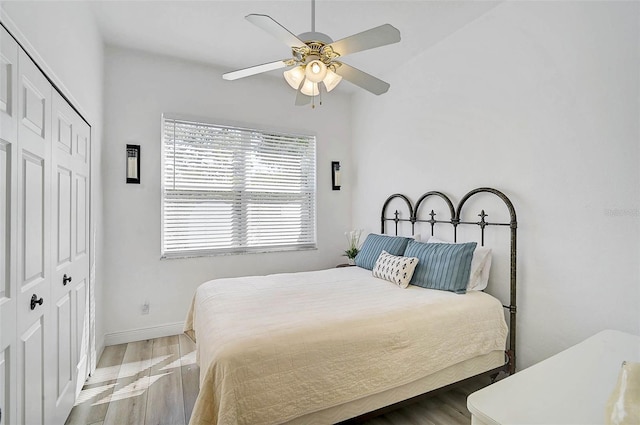 bedroom with a closet, baseboards, ceiling fan, and wood finished floors