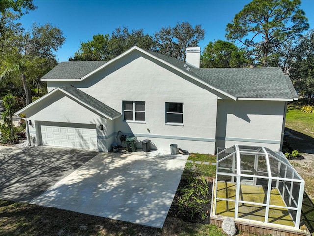 exterior space with a chimney, stucco siding, and a shingled roof