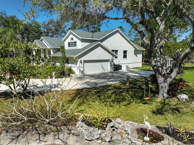 view of side of home featuring stucco siding, a garage, driveway, and a lawn