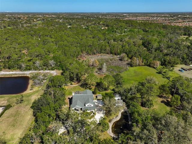 birds eye view of property with a wooded view and a water view