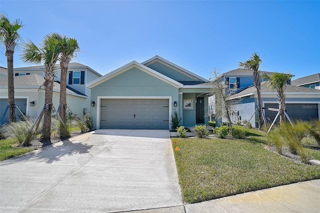 view of front of house featuring concrete driveway, an attached garage, a front yard, and stucco siding