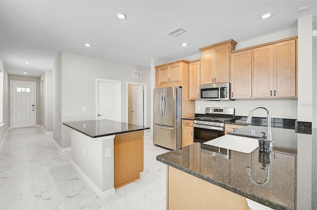 kitchen featuring visible vents, marble finish floor, a sink, appliances with stainless steel finishes, and baseboards