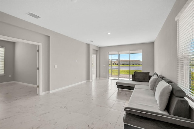 living room featuring visible vents, baseboards, and marble finish floor