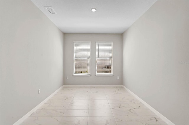 spare room with visible vents, marble finish floor, and baseboards