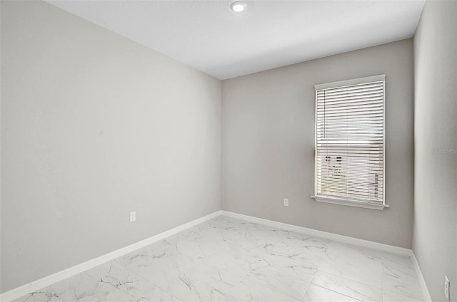 spare room featuring baseboards and marble finish floor