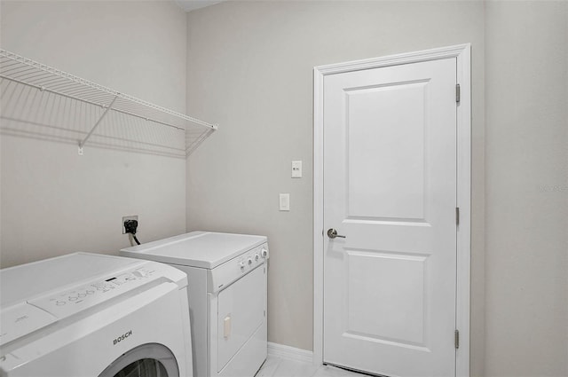 laundry room featuring washer and dryer, baseboards, and laundry area