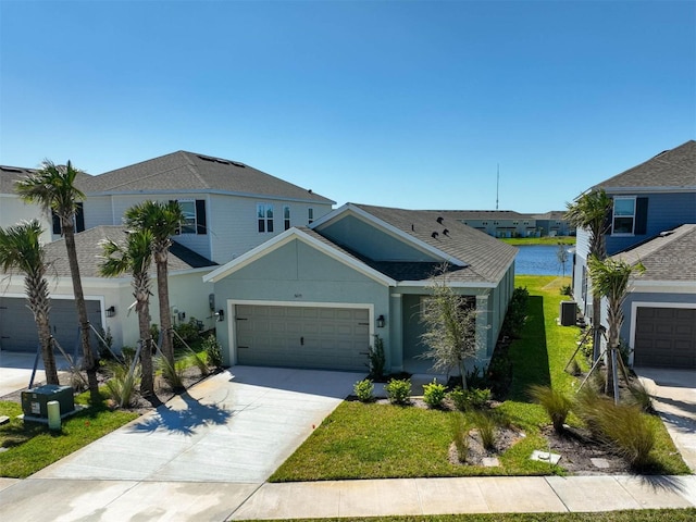 view of front of property with a shingled roof, a front lawn, cooling unit, a garage, and driveway