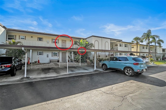 view of building exterior featuring a residential view and covered and uncovered parking