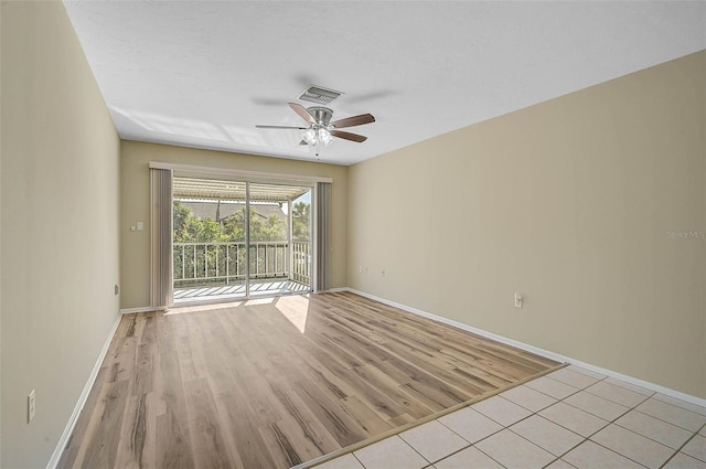 spare room featuring visible vents, baseboards, light wood-style flooring, and a ceiling fan