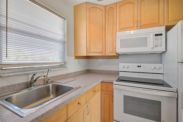 kitchen with a sink, white appliances, light brown cabinets, and light countertops