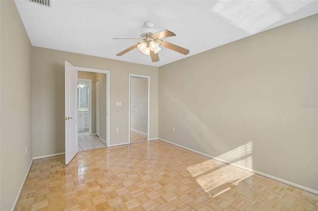 unfurnished bedroom with visible vents, baseboards, a ceiling fan, and ensuite bathroom