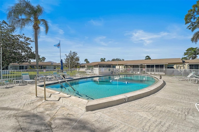 community pool featuring fence and a patio area