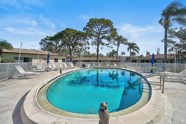 pool with a patio and fence