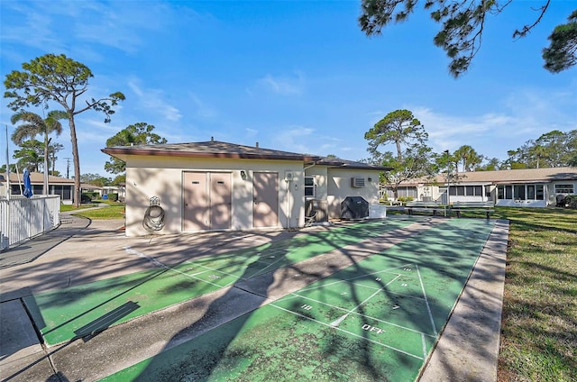 surrounding community featuring shuffleboard and a yard